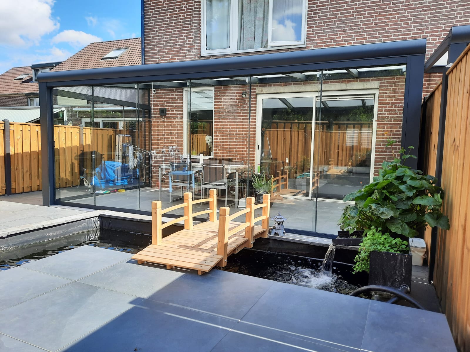 Aluminium terrasoverkapping met glazen schuifwanden bij een woning