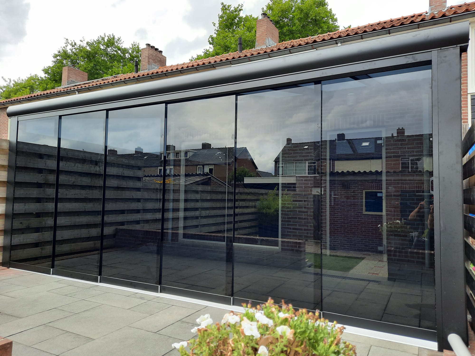 Glazen schuifwanden onder een terrasoverkapping